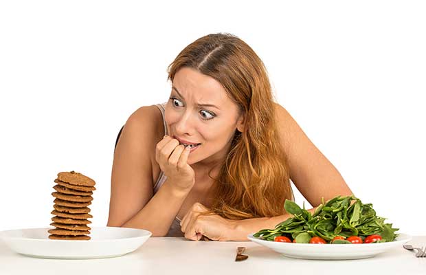 Γυναίκα που αποφασίζει να τρώνε υγιεινά τρόφιμα ή γλυκά μπισκότα